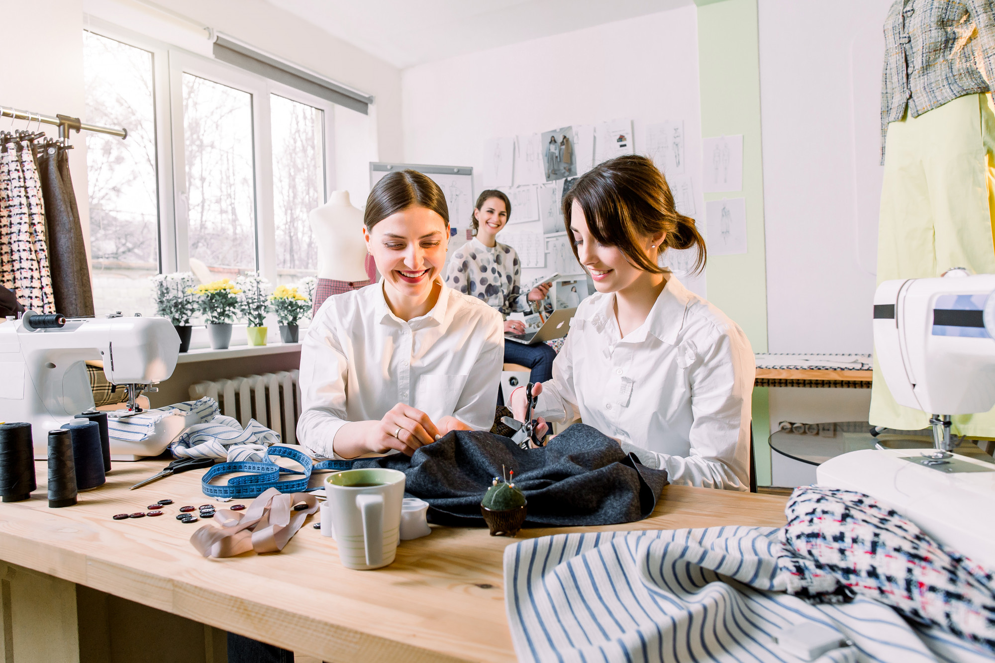 Persone al tavolo dell'atelier che ricamano